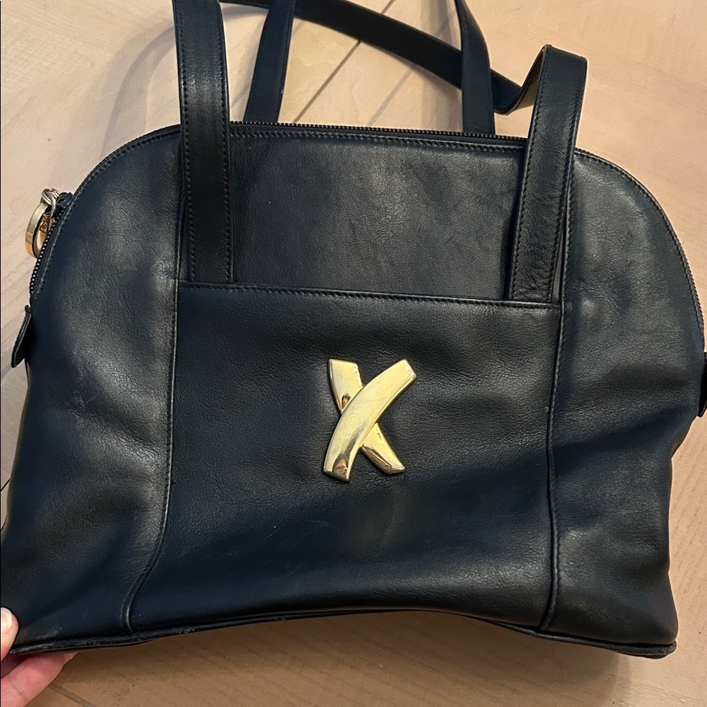 Paloma Picasso black leather shoulder bag featuring signature gold-tone "X". VTG